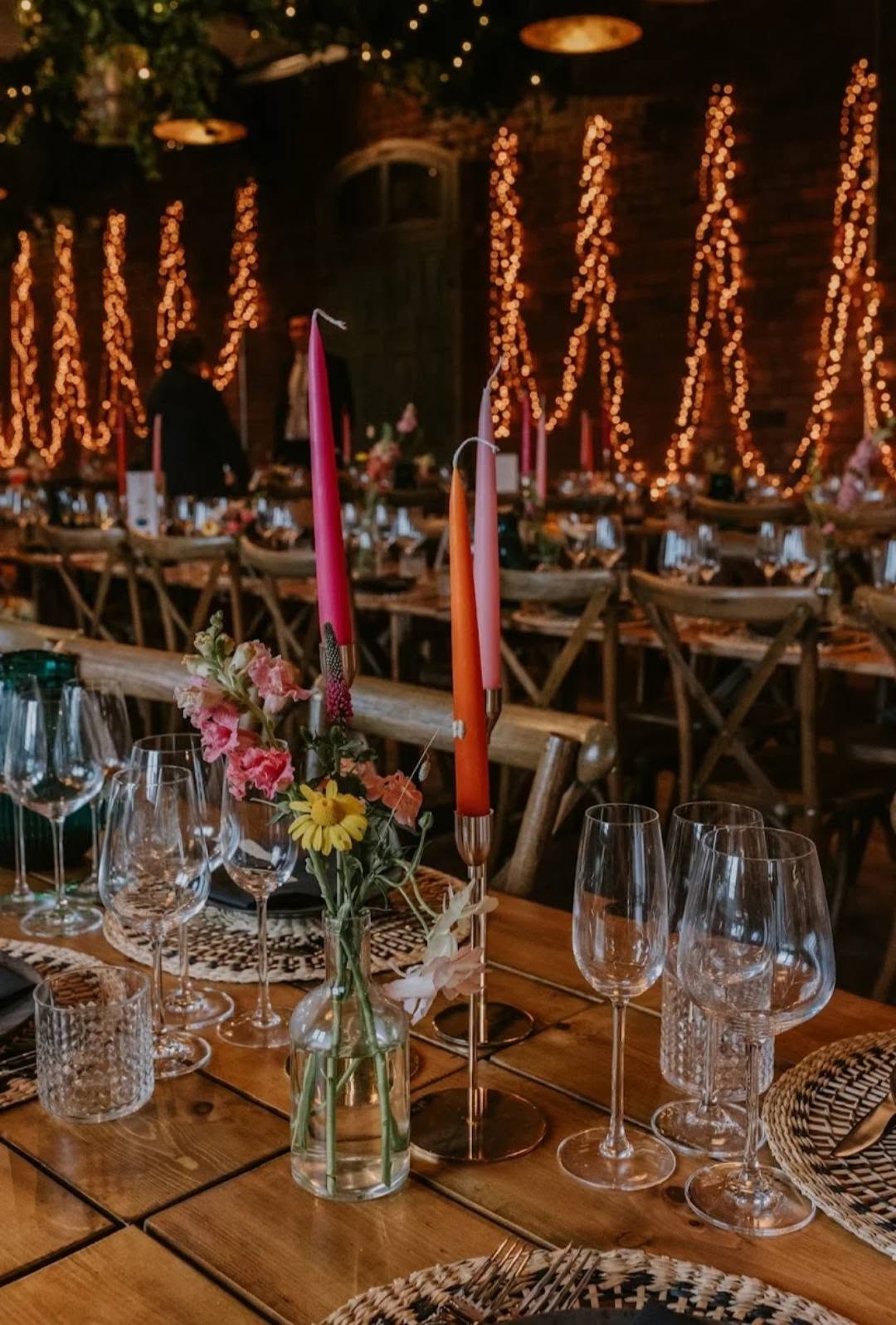 Colourful wedding table details by candlelight